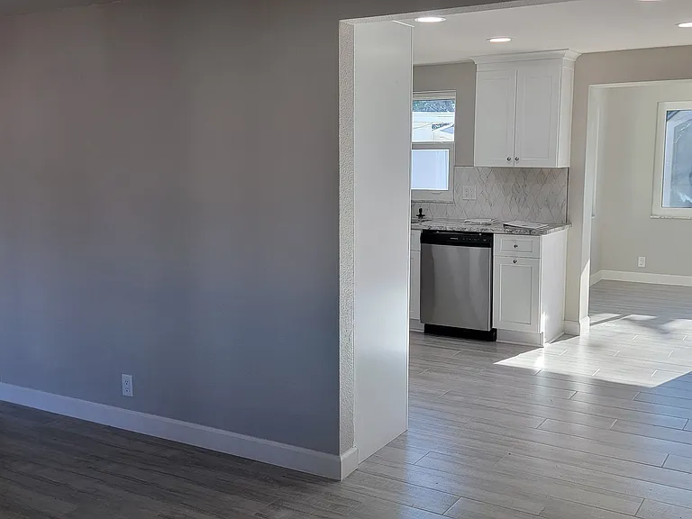 View from living room to kitchen/dining area and enclosed lanai.