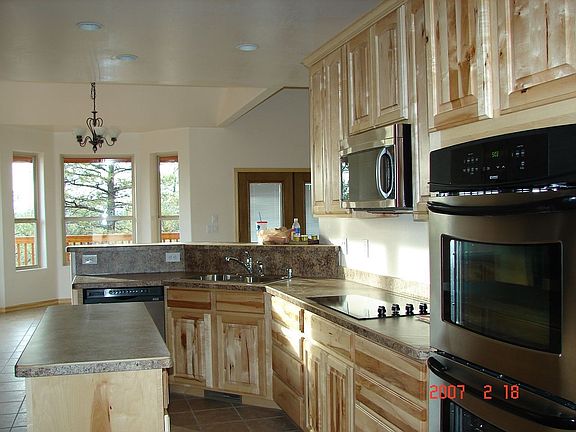 Eatin Island Kitchen Features Knotty Pine Cabinets and SS Appliances