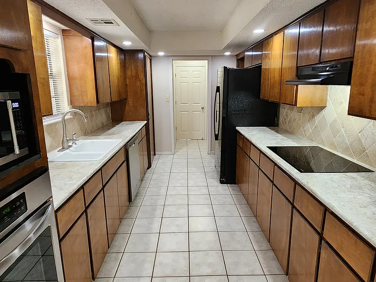 VIEW OF KITCHEN FROM PATIO EATING AREA, NOTICE LAUNDRY OFF THE END OF THE KITCHEN.