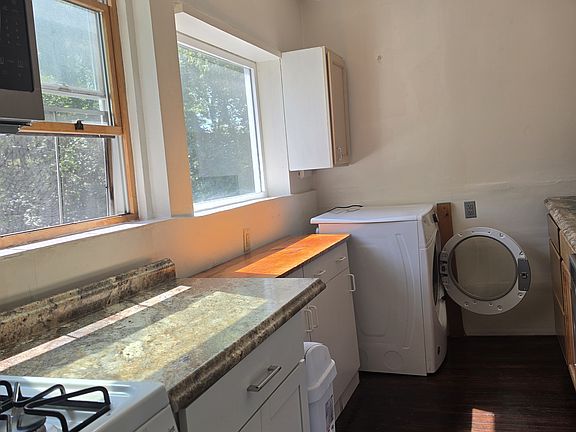 Bright kitchen showing gas range, front loader gas dryer