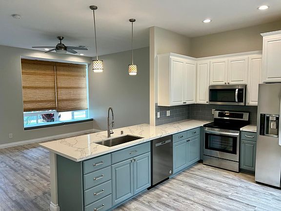 Remodeled kitchen with quartz counters and glass tile backsplash
