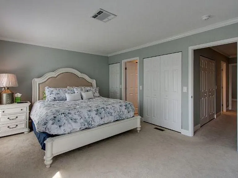 Large Master bedroom with king-size bed, large dresser, TV, en-suite bathroom with shower, and private balcony.