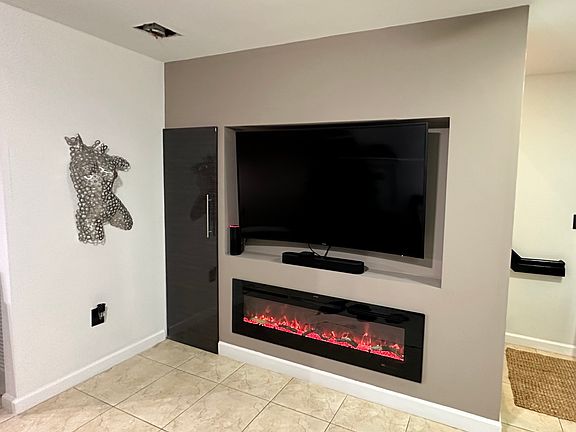 Custom Wall in Living Room area has space for a large TV and has a built-in Modern Fireplace