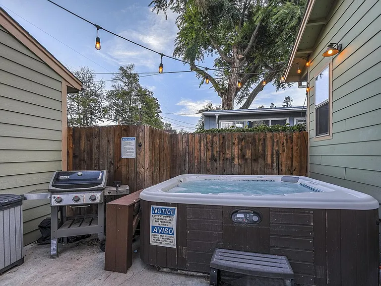 Cozy outdoor area with a hot tub and grill!