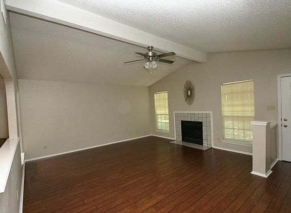 Spacious living area with fireplace, cathedral ceiling and new wood laminate flooring.