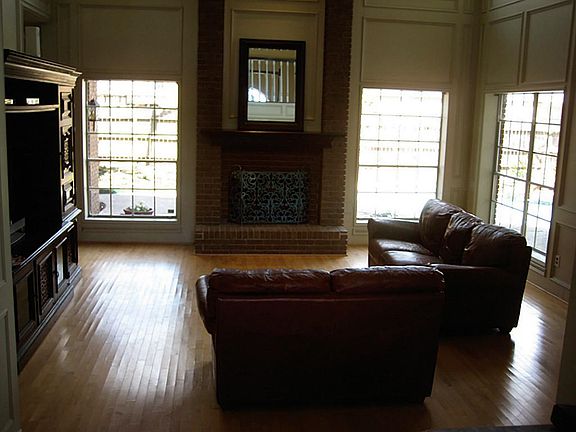 Two story living room with hardwood floors and a view to the backyard