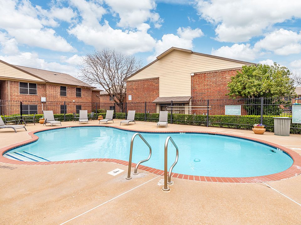 Community swimming pool with open deck space and nearby shaded seating