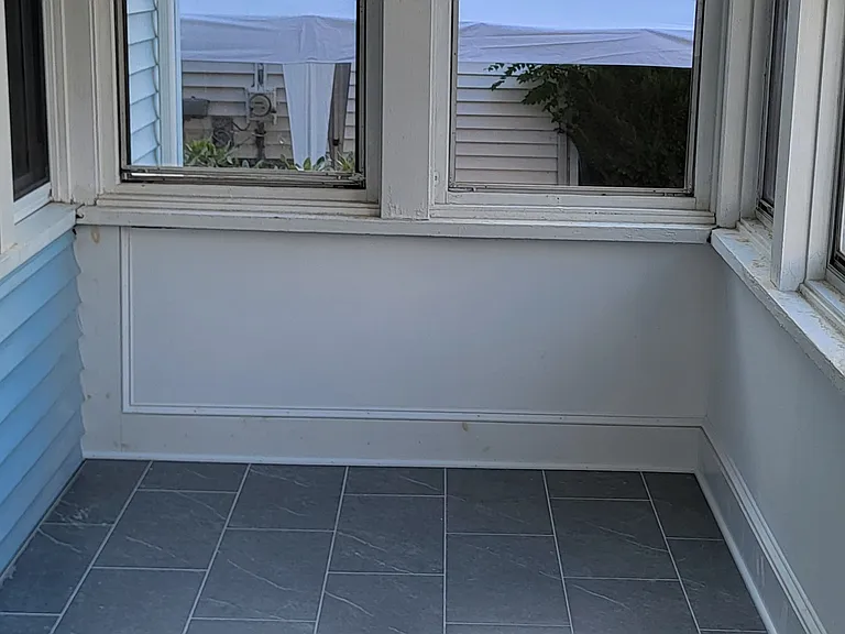 Newly tiled, enclosed front porch.