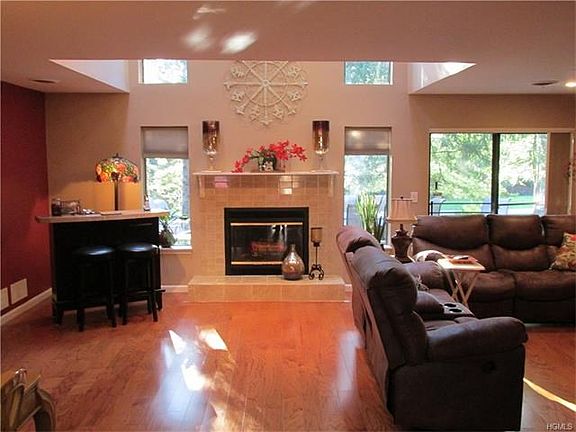 Large open family room with tiled fireplace opens up with cathedral ceilings