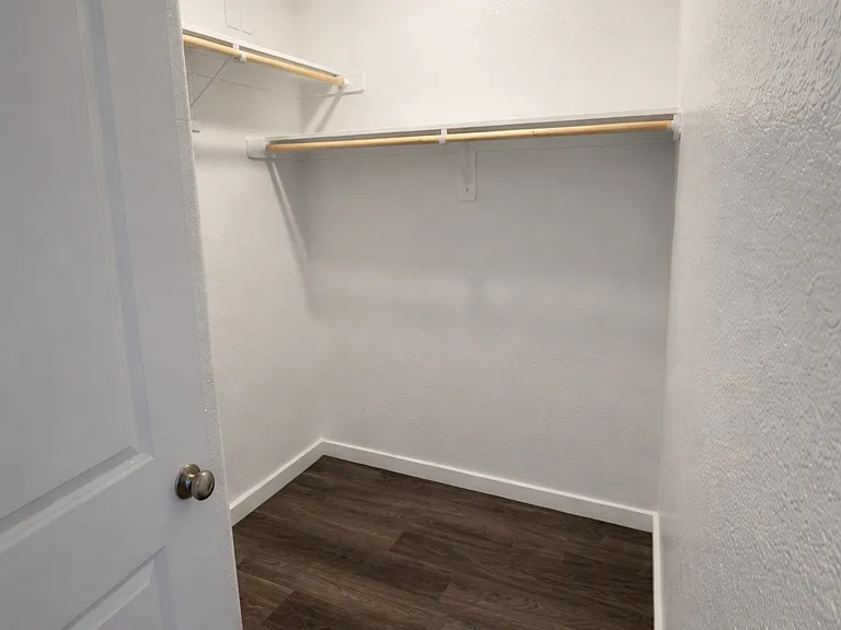 Large primary walk-in closet with built-in shelving.