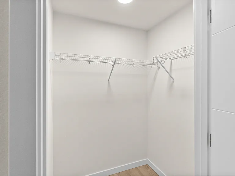 Bright walk-in closet featuring built-in wire shelving for organized, easy storage. Bright walk-in closet featuring built-in wire shelving for organized, easy storage.