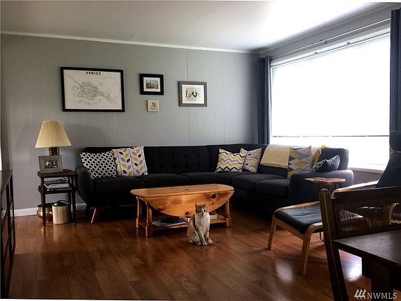 The large, fully fenced back yard has a lush carpet of grass and features mature shade trees and a tool storage shed.