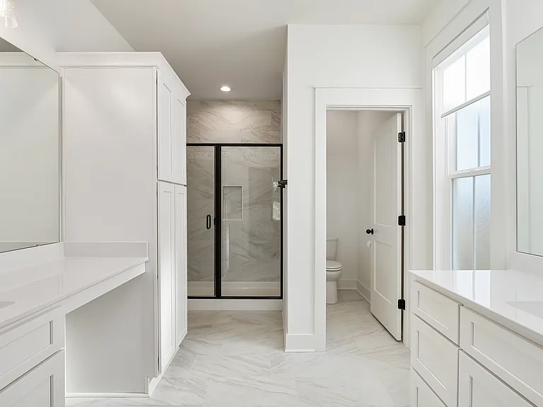 Luxurious Master bathroom with 12X24 white ceramic floor tile and shower. Shaker white cabinets with cultured marble solid white tops and Built in linen closet and private water closet.