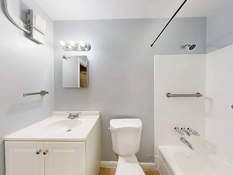 Bright, modern bathroom with sleek fixtures, ample lighting, and a stylish white vanity.