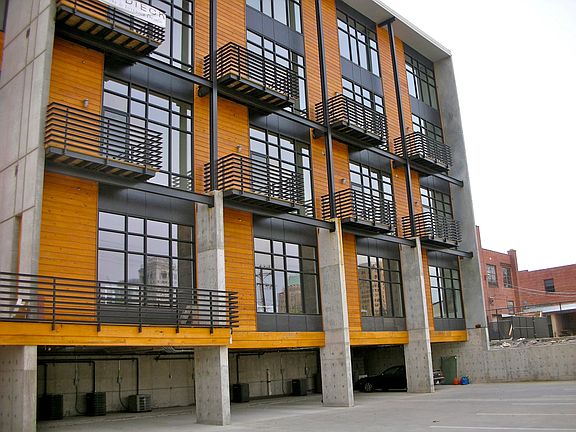 North to south view of rear of Loft building. Covered parking on basement floor . Unit 109 on second level on extreme right of photo