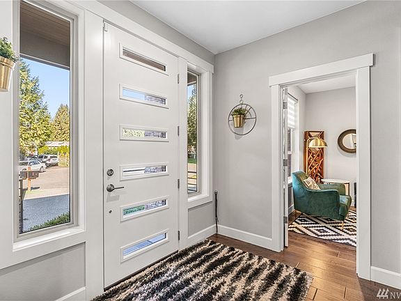 Light and Bright entryway with engineered hardwood floors, white millwork, and agreeable grey walls.  Very inviting with coat closet and access immediately to Home Office or Salon.