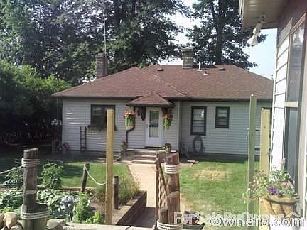 This is the front view of house, lake behind bungalow to right