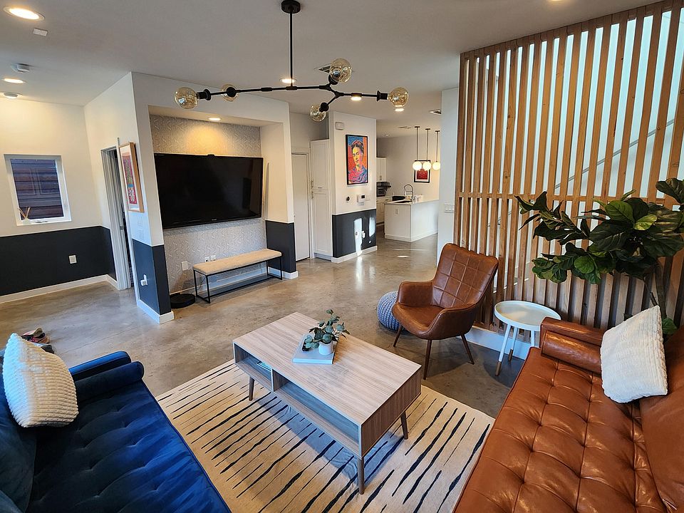 Spacious living room with 70 inch Sharp Aquos TV and Roku Express, opens to dining room and kitchen.