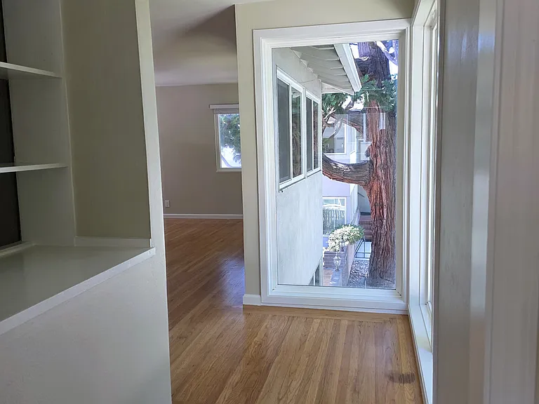walkway between dining area and the large floor to ceiling windows that lead to the living room.