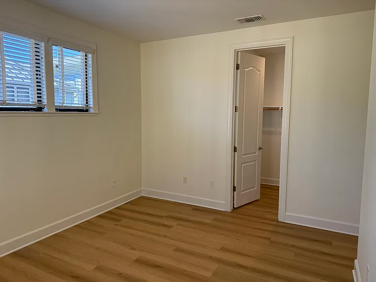 Spacious Bedroom #1 features multiple windows, vinyl flooring, walk-in closet, a separate bathroom sink and share a Jack-and-Jill style bathroom for the bathtub and toilet.