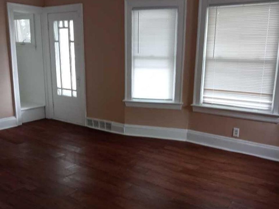 Large livingroom with newly stained floors new windows and fireplace.