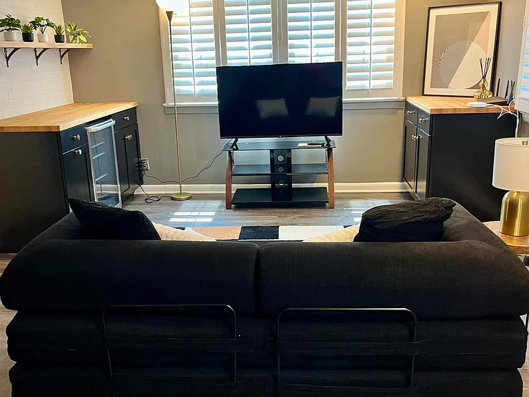 Studio suite in basement with fold-out futon, tv, and beverage fridge.
