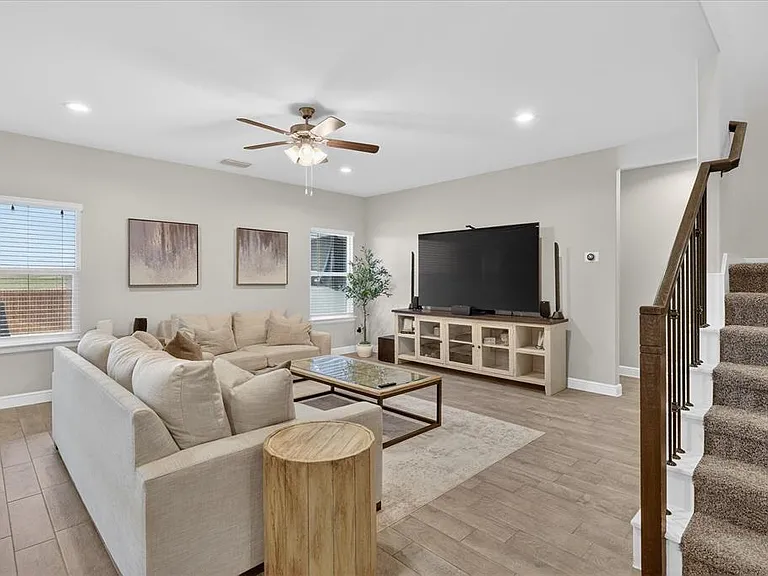 Open-concept living area featuring wood-finish flooring, recessed lighting, and a ceiling fan