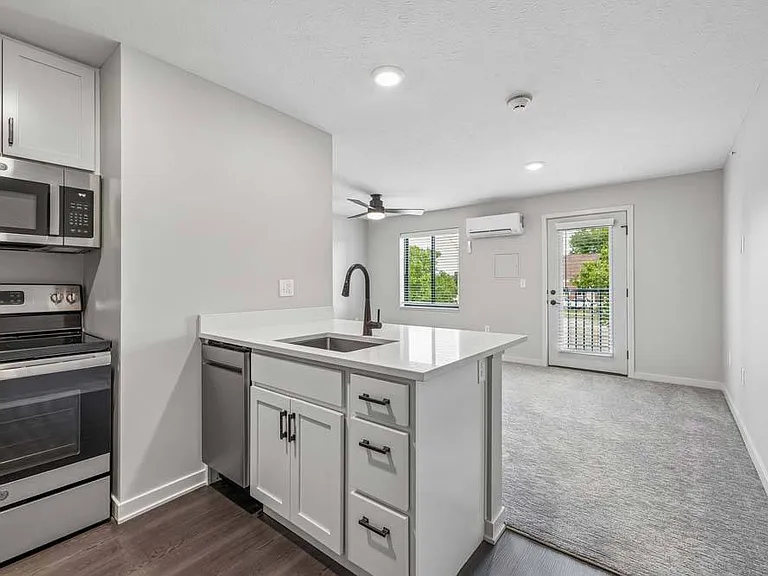 A spacious kitchen island anchors the home's open-concept design, creating a natural gathering place that flows seamlessly into the bright living area.