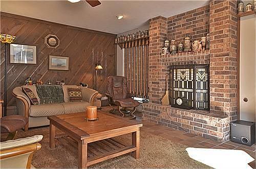 Beautifully bricked fireplace!  Rustic cedar wood paneling and two ceiling fans in the family room.