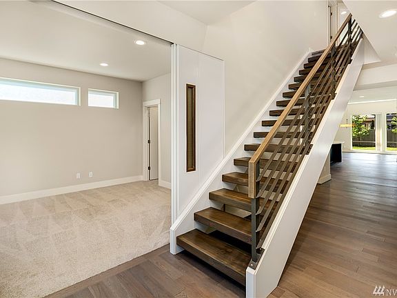 As you enter, be greeted by stunning solid wood floating stairs and the bright, open spaces