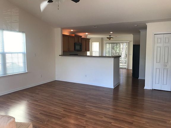 Open living, kitchen & dining area with laundry closet leading out to screen porch