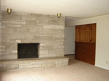 The Living Room has a stone wall fireplace.....shows so well in this large room. There is a very large window on the front wall of the Living Room that looks out to the front of the home.