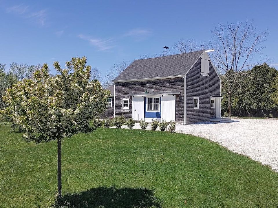 Pastoral setting with thoughtful details like custom weather vane, new flowering laurel plantings, barn doors.