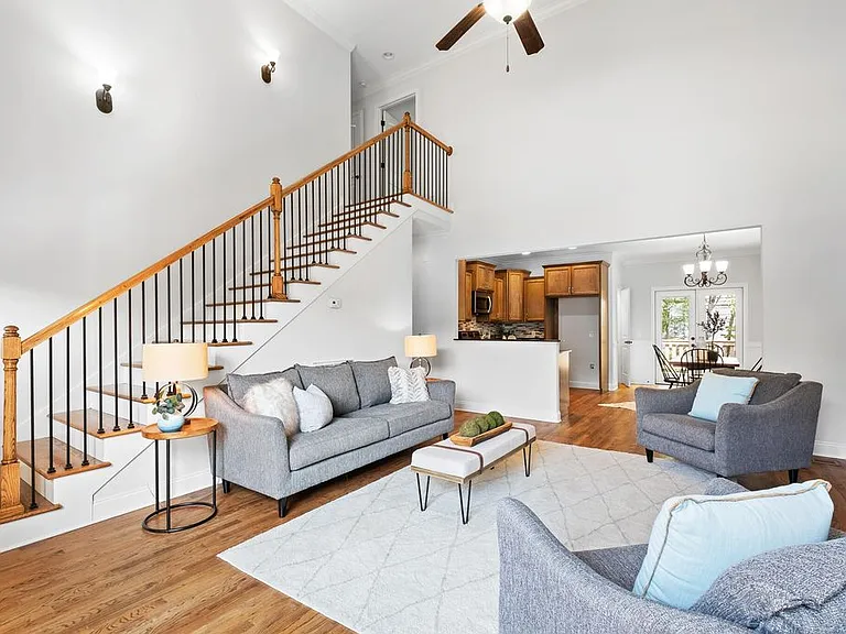 Living room with ceiling light/fan, hardwood floors.