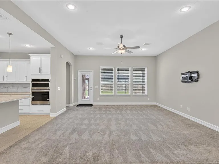 Open-concept living area featuring light gray walls, recessed lighting, and a ceiling fan