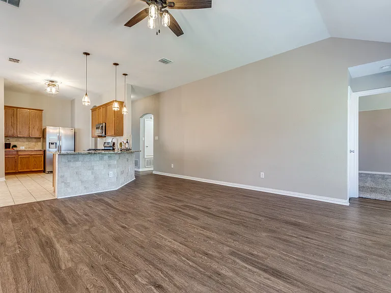 Family room overlooking the kitchen, breakfast nook, additional bar seating and primary bedroom.