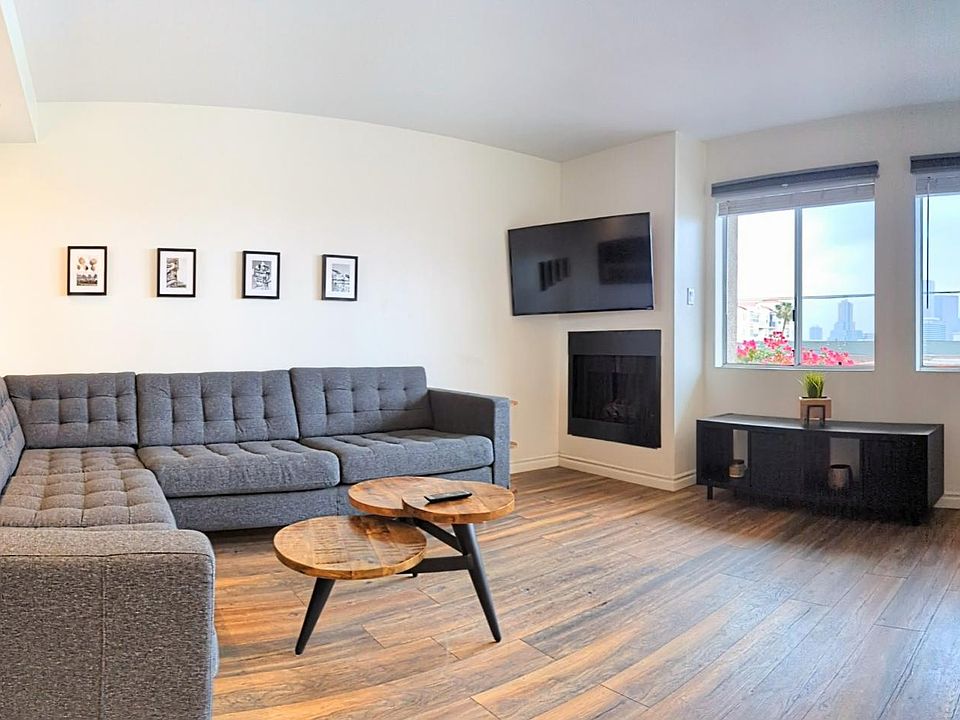 Living Room with Spacious Modular Couch, TV, Fireplace, Home Cocktail Bar, Mini-Fridge, and Iconic Downtown LA Skyline Views!