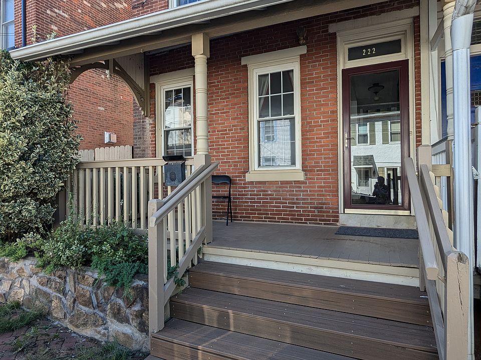 Front facade of the townhome showing entry and front porch from the sidewalk.