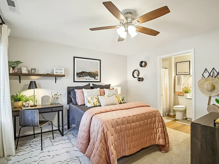 Enhance your living experience with a spacious bedroom featuring soft carpeting and a private en-suite bathroom at The Preserve Murfreesboro apartments.