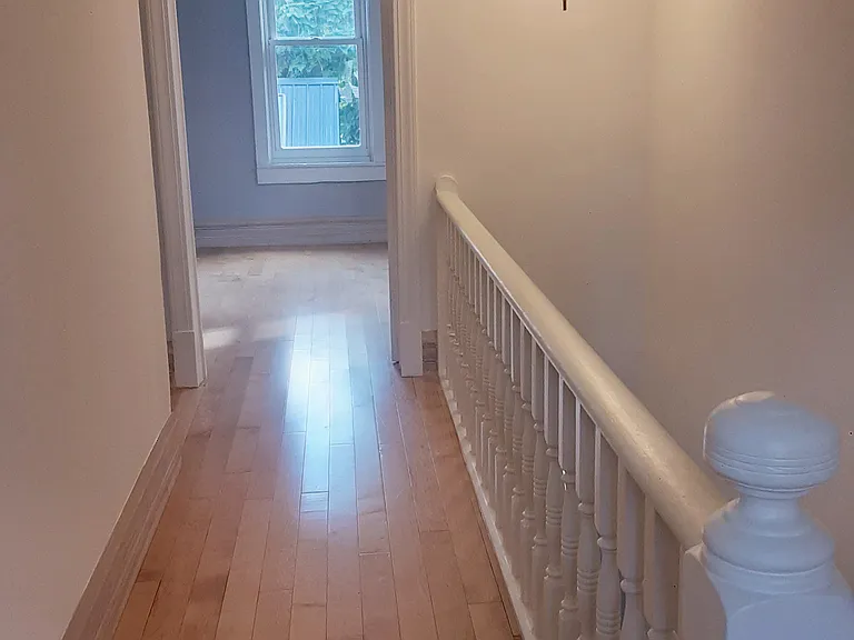 Upstairs hallway showing second bedroom at the end. Bathroom is at the end of the hall to the left. Primary bedroom is to the immediate left.