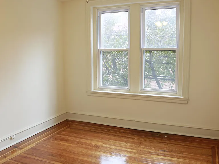 A bedroom with a ceiling fan and light.
hardwood floor.