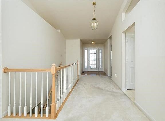 View of entry with wood floors, upgraded front door, open stair to lower level.