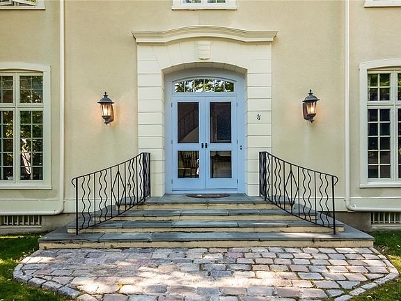 Natural cobble stone and bluestone steps lead to the double door entrance.