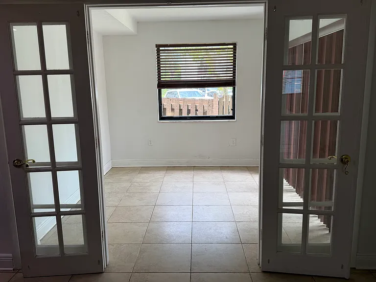 Side sun room with glass door that leads to patio.