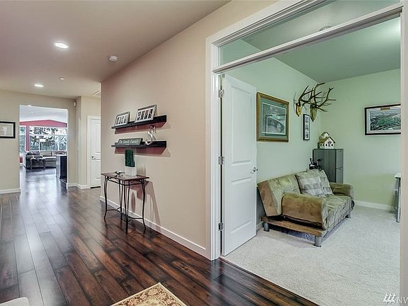 Just off the entry you'll find the den with double door entry. This home boasts many design features to support someone with mobility challenges, including custom ramps to access the front door, extra wide hallways, low threshold showers and more.