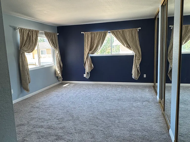 Massive primary bedroom with brand-new carpet and large mirrored closets