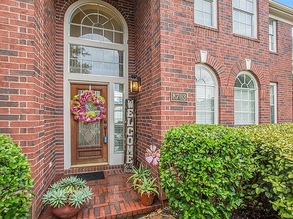 Beautiful brick elevation with arched windows and welcoming entry.