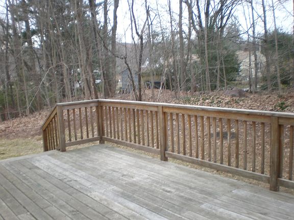 Large deck backs to the woods in a private yard