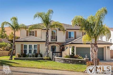 Stacked stone accents on planters with lighted pilasters. Courtyard entrance.