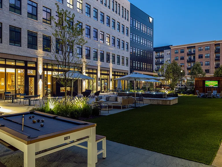 Wellsmith western courtyard with gaming tables, seating, and an outdoor theater
